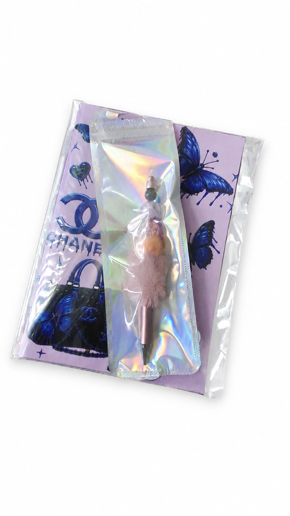 Purple butterfly A5 notebook and handmade fluffy beaded pen presented together in clear and holographic protective packaging.