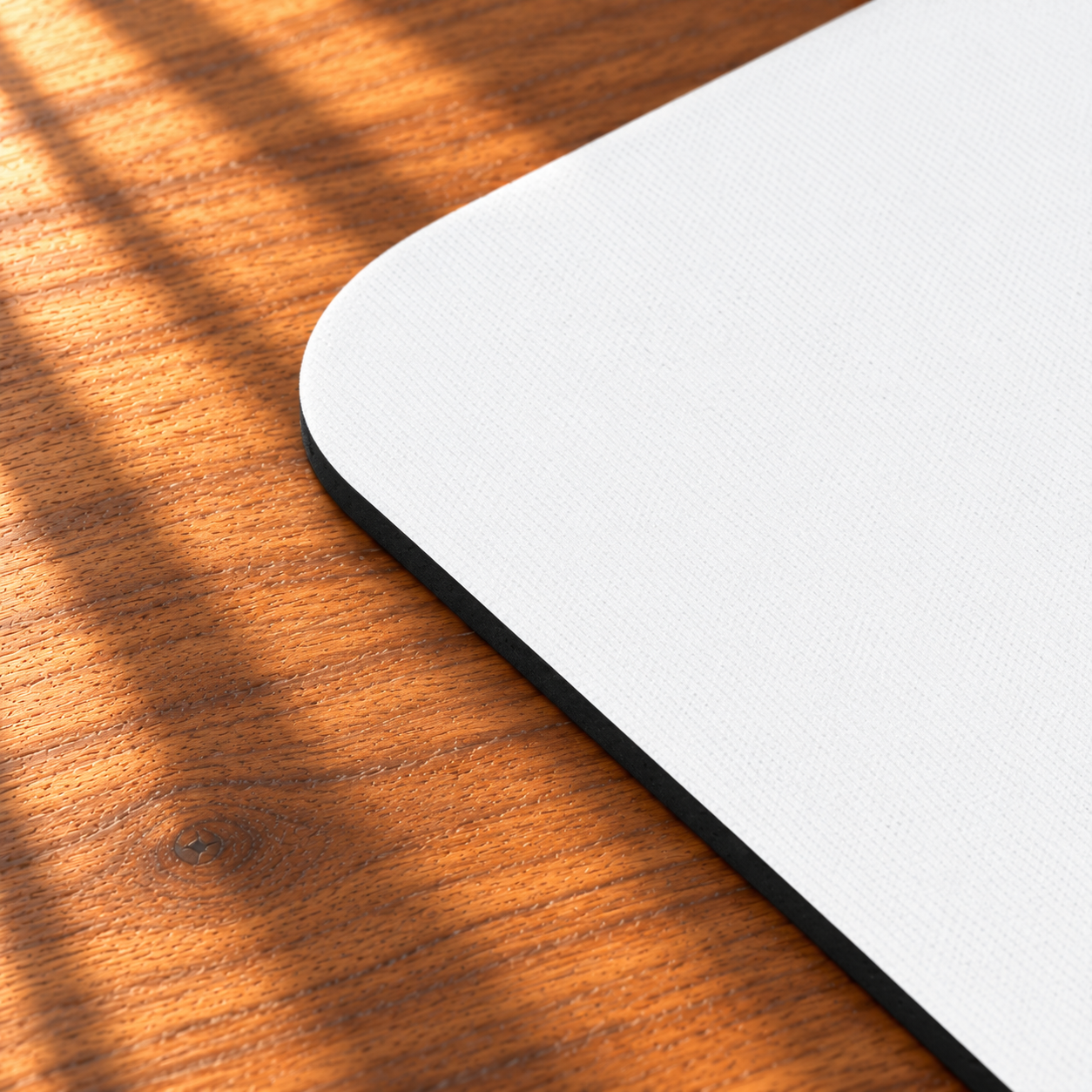 Close-up of the Grandmother/Girl Floral mouse pad showing its rounded corner, white fabric surface, and thin black rubber base.